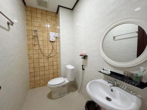 a bathroom with a toilet and a sink and a mirror at Meesokxay Hotel Vang Vieng in Vang Vieng