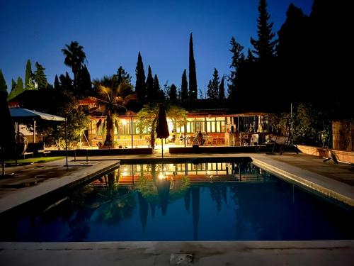 a swimming pool at night with a building in the background at Spacious Garden Villa, private pool, huge grounds with orange trees in Dos Hermanas