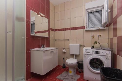 a bathroom with a toilet sink and a washing machine at Holiday Home Vele with pool in Vrgorac