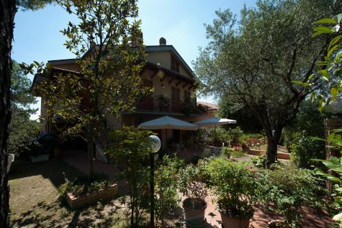 a building with an umbrella and trees in front of it at B&B Casa Cettina in Macerata