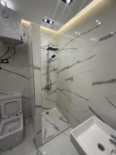 a white bathroom with a shower and a sink at Happy apartment 3 in Cairo