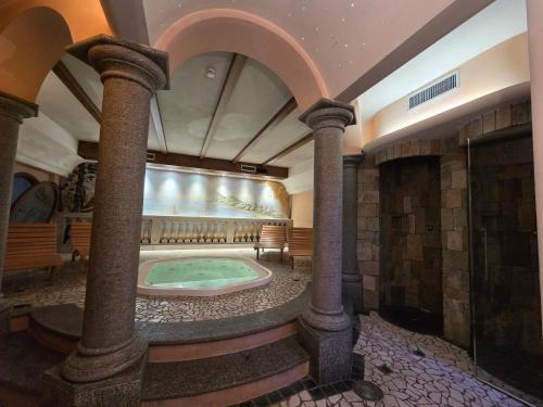 a large room with a hot tub in a building with columns at Hotel La Pastorella in Livigno
