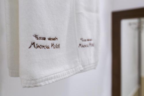 a towel with writing on it on a wall at Mhonsa Hotel in Chiang Mai