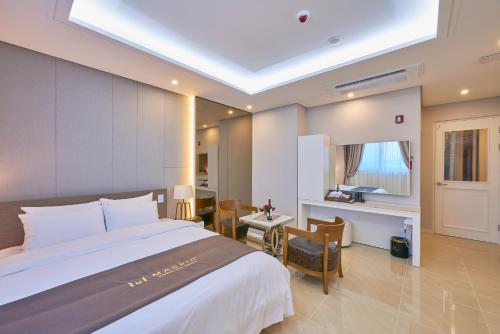 a hotel room with a large bed and a desk at Gwangju Madrid Hotel in Gwangju