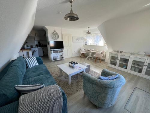 a living room with a blue couch and a table at Boddenhaus Darss in Wieck