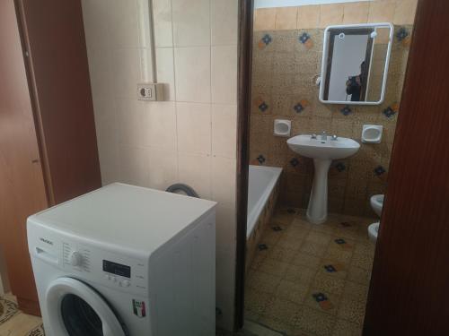 a bathroom with a washing machine and a sink at Oasi Relax Lago Omodeo Casa Demartis in Tadasuni