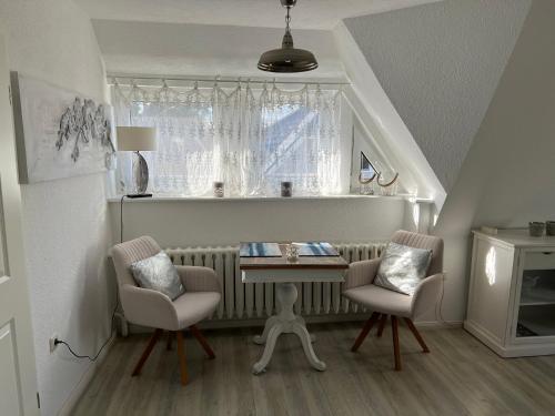 a room with two chairs and a table and a window at Boddenhaus Darss in Wieck