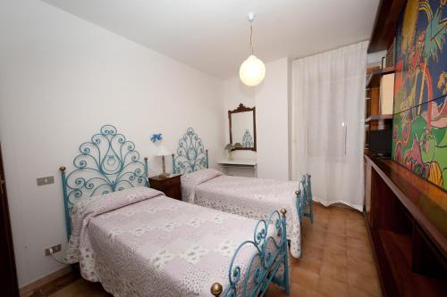 a bedroom with two beds and a mirror at B&B Casa Cettina in Macerata