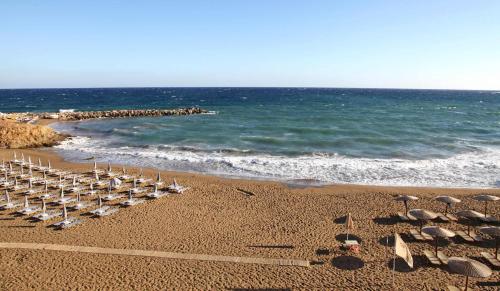 a group of chairs and umbrellas on a beach at Vertigo Stone Villa - Roumeli Private Pool Escape in Roumelí