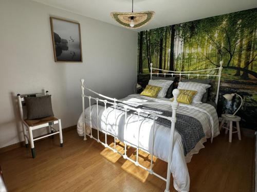 a bedroom with a white bed with a painting on the wall at Gîte campagne et clim - 4 pers. - FR-1-489-84 in Saint-Bonnet-Tronçais