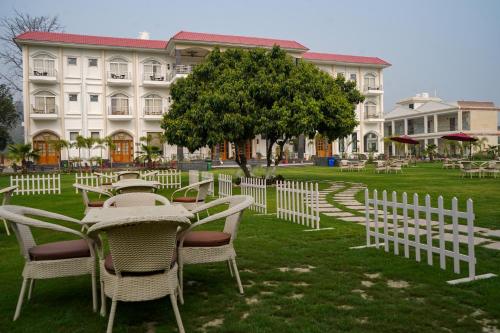 a group of tables and chairs in front of a building at The Lychee Hotel & Resort by The Altruist in Rāmnagar