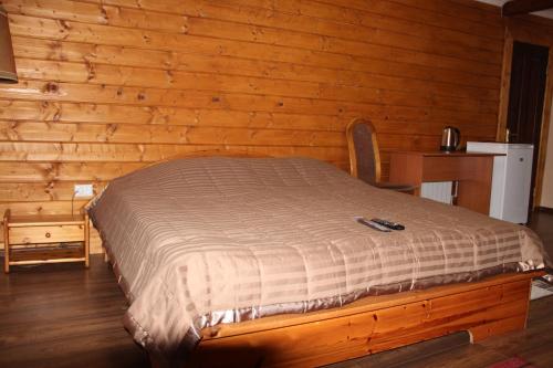 a bed in a room with a wooden wall at Hotel Duet in Maydan