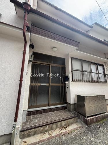 a building with a sign on the front of it at P-STAY宮島大西町Hanada in Hatsukaichi