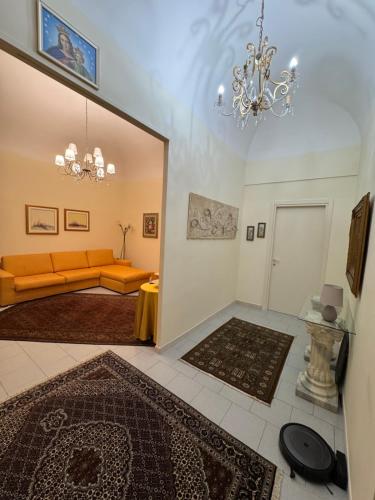 a living room with an orange couch and a chandelier at House S&D in Giarre