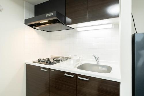 a kitchen with a sink and a stove at Laguna Verde Misono 103 in Sapporo