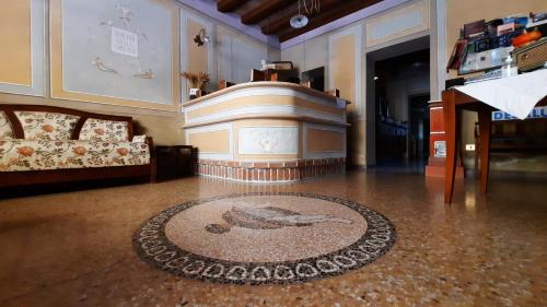 a room with a couch and a rug on the floor at Albergo Giulia Gonzaga in Sabbioneta