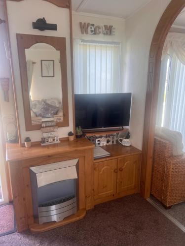 a living room with a television and a tv stand at A7 caravan The Chase Ingoldmells in Ingoldmells