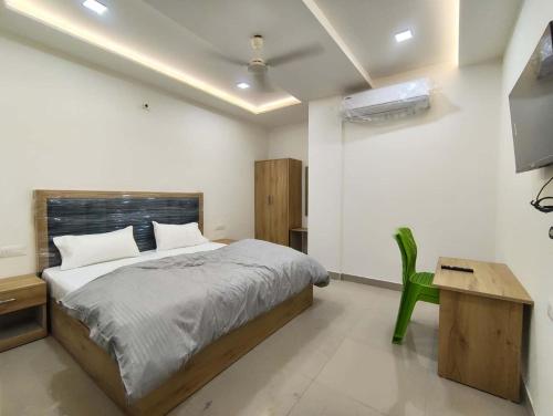 a bedroom with a bed and a green chair at Hotel The Skyluxe in Agra