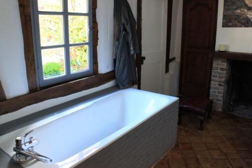 a bath tub in a bathroom with a window at La Bonne Auberge - Seine Panorama SAS in Vieux-Port