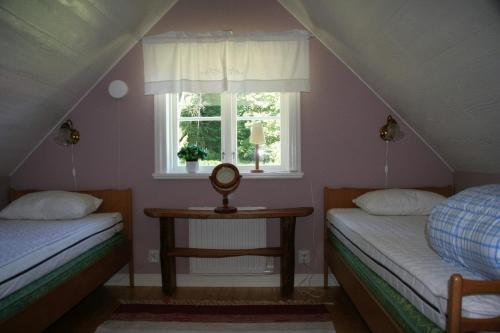 two beds in a room with a window at Wråen Svartrå in Svartrå