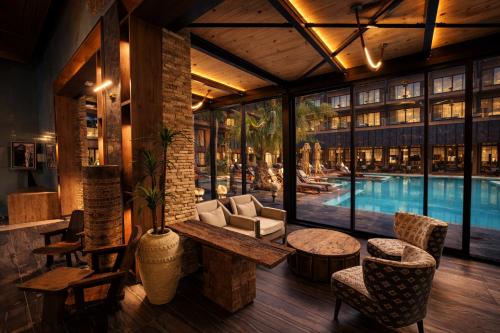 a lobby with a pool and a table and chairs at Taghazout Palm Hotel in Taghazout
