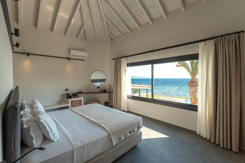 a bedroom with a bed and a view of the ocean at Hotel Angels in Mythimna