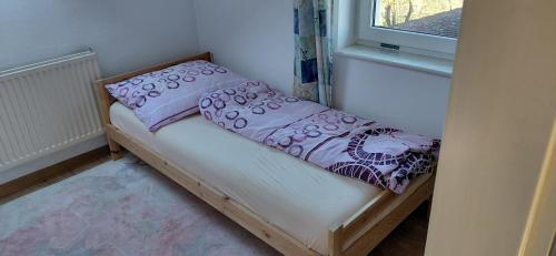 a small bed in a room with a window at Apartmán Hodoňovice in Frýdek-Místek