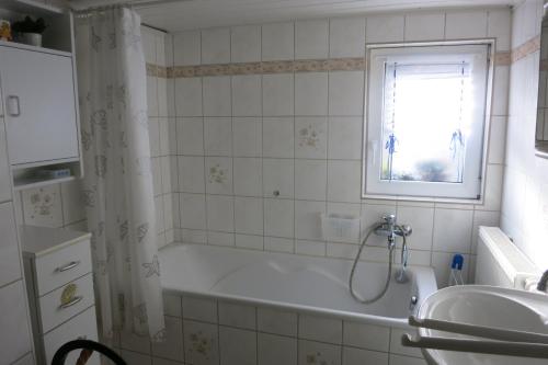 a bathroom with a bath tub and a sink at Wanderunterkunft in Frauenwald in Frauenwald