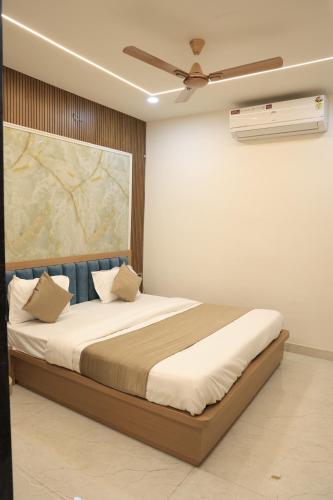 a bedroom with a bed with a ceiling fan at Hotel Krishna Residency in Udaipur