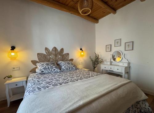 a bedroom with a large bed and two white tables at La Casa de Célia in Valencia de Don Juan