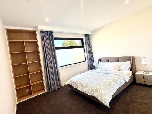 a bedroom with a bed and a large window at Williamstown Village 2 in Williamstown