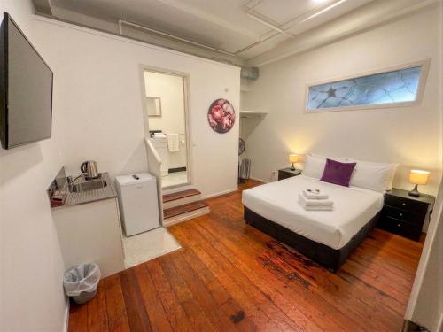 a small bedroom with a bed and a window at Aura Hotel in Wellington