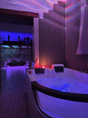 ein großes Badezimmer mit Badewanne und violetter Beleuchtung in der Unterkunft Trully in Alberobello
