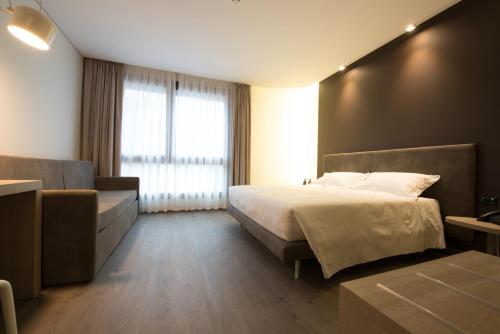 a bedroom with a bed and a couch and a window at Fuori le Mura in Altamura