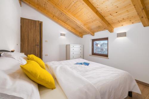 a bedroom with a large white bed with yellow pillows at Villa STOCK 66 by Villsy in Štokovci