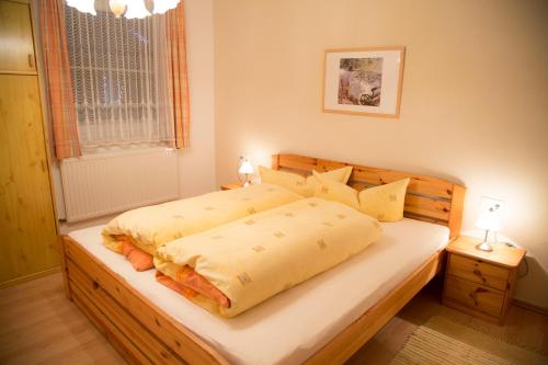 Schlafzimmer mit einem großen Bett mit einem Kopfteil aus Holz in der Unterkunft Appartement Fink in Jerzens
