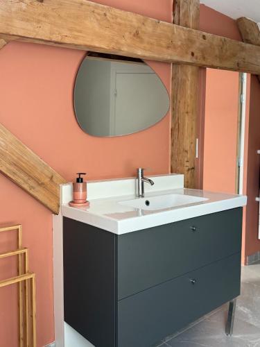 ein Badezimmer mit Waschbecken und Spiegel in der Unterkunft Leonard in Landerneau