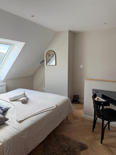 ein weißes Schlafzimmer mit Bett und Schreibtisch in der Unterkunft Leonard in Landerneau