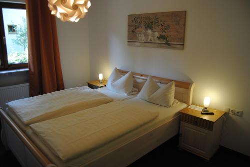 ein Schlafzimmer mit einem großen Bett mit zwei Leuchten in der Unterkunft Ferienwohnung am Donnersberg in Dannenfels