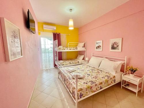 a bedroom with a bed and a pink wall at FLY, Oneiropagida, Aegina in Vathí