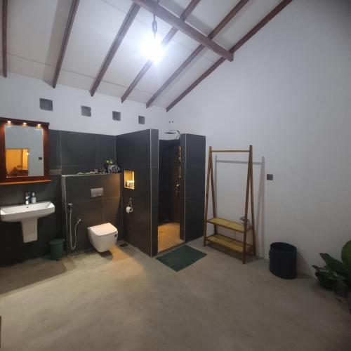 a bathroom with a toilet and a sink and a shower at Shells By D in Negombo