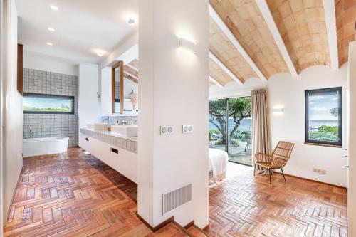 a master bathroom with a large bed and a large window at Casa del Capitan in Cadaqués