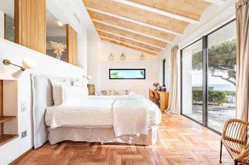 a bedroom with a white bed and a large window at Casa del Capitan in Cadaqués