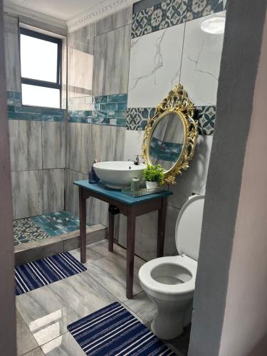a bathroom with a sink and a toilet and a mirror at Ocean gate in Hartbeespoort