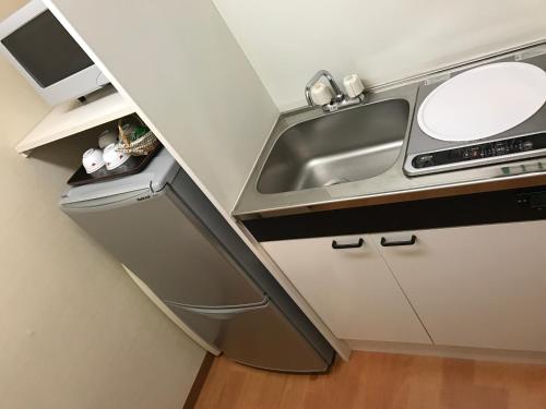 a small kitchen with a sink and a counter at New Central Hotel Katsuta in Hitachinaka
