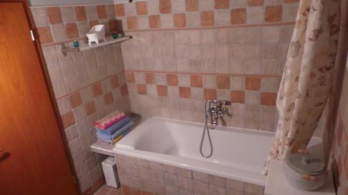a bathroom with a bath tub with a shower curtain at Keith Lakewood Villa in Balatonfüred