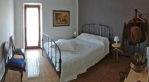 Un dormitorio con una gran cama blanca y una ventana en Dolce Casa, en Vezzano Ligure
