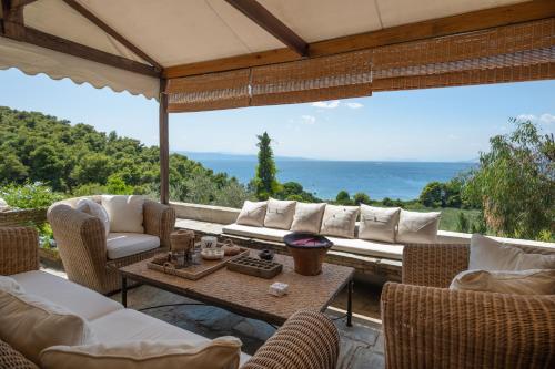 a patio with a couch and chairs and a table at Liogerma Boutique Home in Skiathos