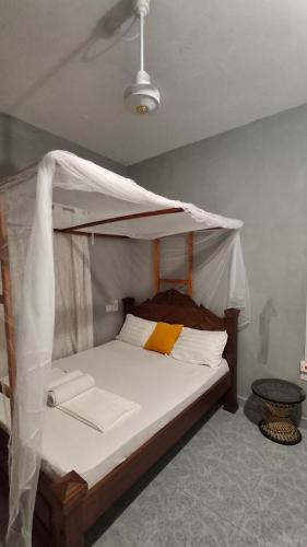 a bed with a canopy in a room at Zai Homes Watamu in Watamu