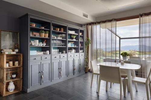 a dining room with a table and a large cabinet at Hotel San Prudentzio in Getaria
